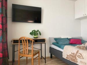 um quarto com uma secretária e um sofá com uma cadeira em Ydinkeskustassa, uusi yksiö+ autohallipaikka em Tampere