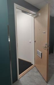 an open door in an empty room with a door sidx sidx at Ydinkeskustassa, uusi yksiö+ autohallipaikka in Tampere