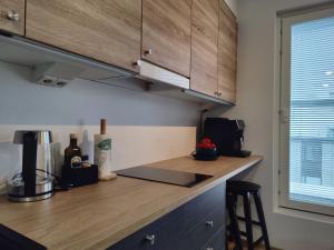 eine Küche mit Holzschränken und einer Arbeitsplatte in der Unterkunft Ydinkeskustassa, uusi yksiö+ autohallipaikka in Tampere