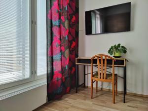 a table and a chair in a room with a window at Ydinkeskustassa, uusi yksiö+ autohallipaikka in Tampere