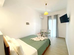 a bedroom with a bed and a table with chairs at Tzamaros Studios in Mérikhas
