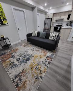 a living room with a black couch and a rug at Luxury suite in Calgary NW in Calgary