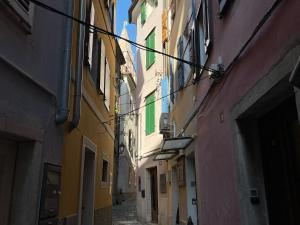 un callejón con edificios en una ciudad en Apartments Piranom, en Piran