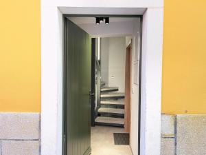un pasillo con una puerta verde y escaleras en un edificio en Apartments Piranom, en Piran