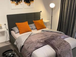 een bed met oranje en grijze kussens in een kamer bij Apartments Piranom in Piran +34 foto's