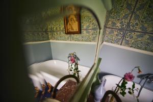 a bathroom with a bath tub and a mirror at Heima í Stovu in Hvalba