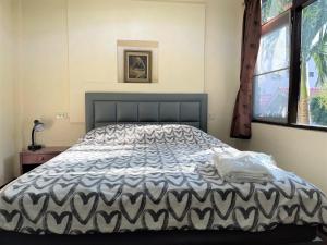 a bedroom with a bed with a black and white comforter at Taphouse in Hua Hin
