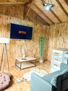 a living room with a tv on a wooden wall at Akçakoca ağaç ev in Duzce