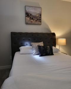 Luxury suite in Calgary NW في كالغاري: غرفة نوم بسرير ابيض كبير مع وسادتين