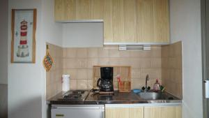 een keuken met een wastafel en een koffiezetapparaat op het aanrecht bij Ancre et Mouettes in Saint-Cyprien