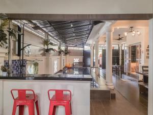 a kitchen with two red stools at a counter at Pool Villa Max Bath Tub BBQ Steamboat Party 5Bedroom 23Pax Full Airconditioned in Melaka
