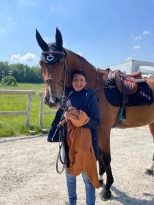 Un homme se tient à côté d'un cheval dans l'établissement Hébergements Insolites dans tonneaux - Gite Le Coup de Foudre, à Vimoutiers