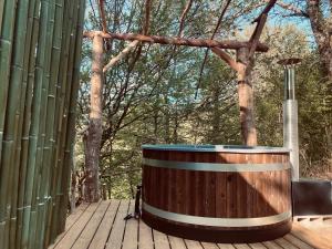 una bañera de madera en una terraza de madera en Domaine de Bourbacoup, en Tulle