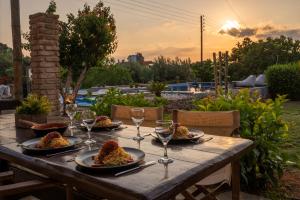 a wooden table with plates of food and wine glasses at Villa34 Family resort Renew, Relax, Revitalise & Spa Suite in Aghia Marina