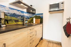 een keuken met houten kasten en een schilderij aan de muur bij Ferienapartment Marktblick in Oberstdorf +3 foto's