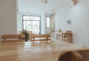 a living room with a table and chairs at Phanomrung Hostel & Linn Chan Cafe พนมรุ้ง โฮส์เทล แอนด์ ลิณณ์จัง คาเฟ่ in Buriram