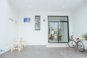 a bike parked next to a white wall at Phanomrung Hostel & Linn Chan Cafe พนมรุ้ง โฮส์เทล แอนด์ ลิณณ์จัง คาเฟ่ in Buriram