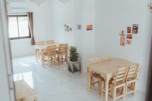a dining room with wooden tables and chairs at Phanomrung Hostel & Linn Chan Cafe พนมรุ้ง โฮส์เทล แอนด์ ลิณณ์จัง คาเฟ่ in Buriram