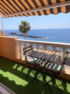 een balkon met een tafel en een stoel en de oceaan bij Blue relax Candelaria in Candelaria