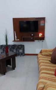 a living room with a couch and a tv on the wall at Cabañas Montoya in Paraná