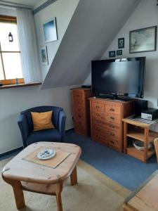 ein Wohnzimmer mit einem TV und einem Tisch in der Unterkunft Apartment Holunderbusch in Schönberger Strand