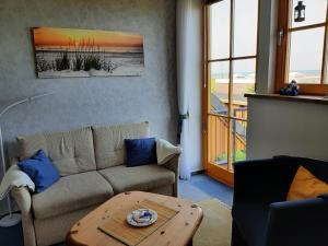 un soggiorno con divano e tavolo di Apartment Holunderbusch a Schönberger Strand
