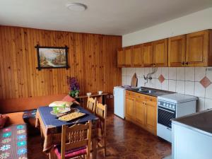 Gacko的住宿－Čemerno Cottage，一间带桌子的厨房和一间餐厅