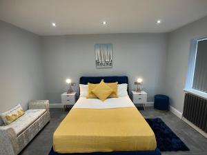 1 dormitorio con 1 cama grande y 1 sofá en Newly refurbished 4 Bedroom House-Sleep 8-Free parking, en Canvey