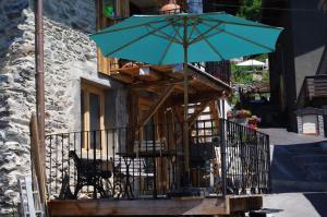 BozelにあるAppartement Dans Chalet de Montagneのバルコニー(緑のパラソル、テーブル、椅子付)