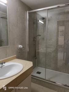 baño con lavabo y ducha con puerta de cristal en Sea ​​apartments, en La Pineda