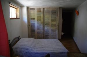 a bedroom with a bed and a wooden closet at Appartement Dans Chalet de Montagne in Bozel