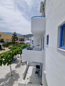 een balkon van een wit gebouw met een raam bij Leonidas Studios & Apartments in Georgioupolis