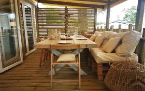 un patio con sofá y una mesa en el porche en Le Bungalow du Ferret - Mobil Home Premium en Claouey
