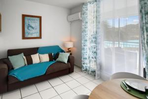 sala de estar con sofá y ventana en En bord de plage Orient Bay, grand studio 4p, en Saint Martin