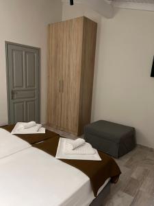 a room with two beds and a cabinet with towels at Saint Spiridon Hotel in Kassiopi