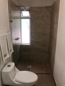 a bathroom with a toilet and a window at Hotel Metropolitan in Guadalajara