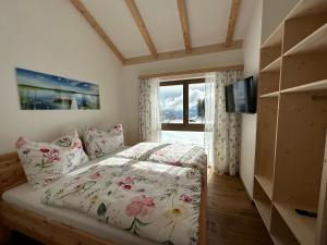 1 dormitorio con cama y ventana en Berglisl - direkt an der Schipiste! Neue Ferienwohnung mit Sauna, en Klippitztorl