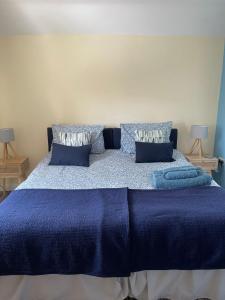 ein Schlafzimmer mit einem blauen Bett mit blauer Bettwäsche und Kissen in der Unterkunft Bowtree House Bed and Breakfast in Grantham