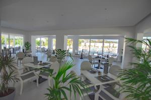 a restaurant with tables and chairs and plants at FRESH HOTEL FALIRAKI in Faliraki
