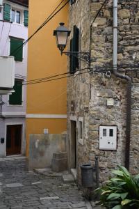 een steegje in een oud gebouw met een straatlicht bij Apartments Piranom in Piran