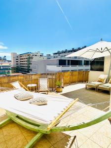a hammock on top of a patio with a building at Caparica Rooftop Beach Apartment in Costa da Caparica