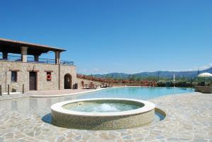 a large swimming pool with a fountain in front of a building at Tenuta Del Perugino in Bettona