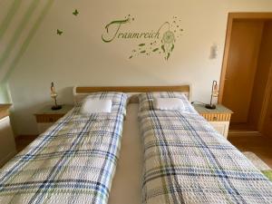 a bedroom with two beds with the word feminism on the wall at Ferienwohnung Röpersberg in Ratzeburg