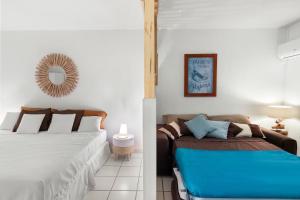 1 dormitorio con 2 camas y sofá en En bord de plage Orient Bay, grand studio 4p, en Saint Martin