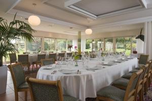 a long table in a room with tables and chairs at Le Manoir du Lys in Bagnoles de l'Orne
