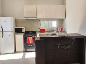a kitchen with a stove and a refrigerator at Hunuc apartamento in Rivadavia