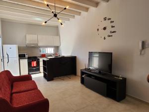 a living room with a tv and a kitchen at Hunuc apartamento in Rivadavia