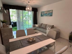a living room with a table and a couch at Villa Bauhaus Silver Wellness Apartman in Siófok