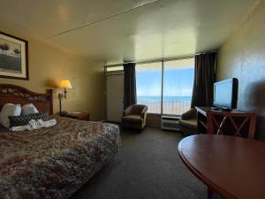 a hotel room with a bed and a view of the ocean at Oceanfront Viking Motel in Myrtle Beach