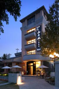 a large building with umbrellas in front of it at Mountain Fish Water Hotel in Jiji